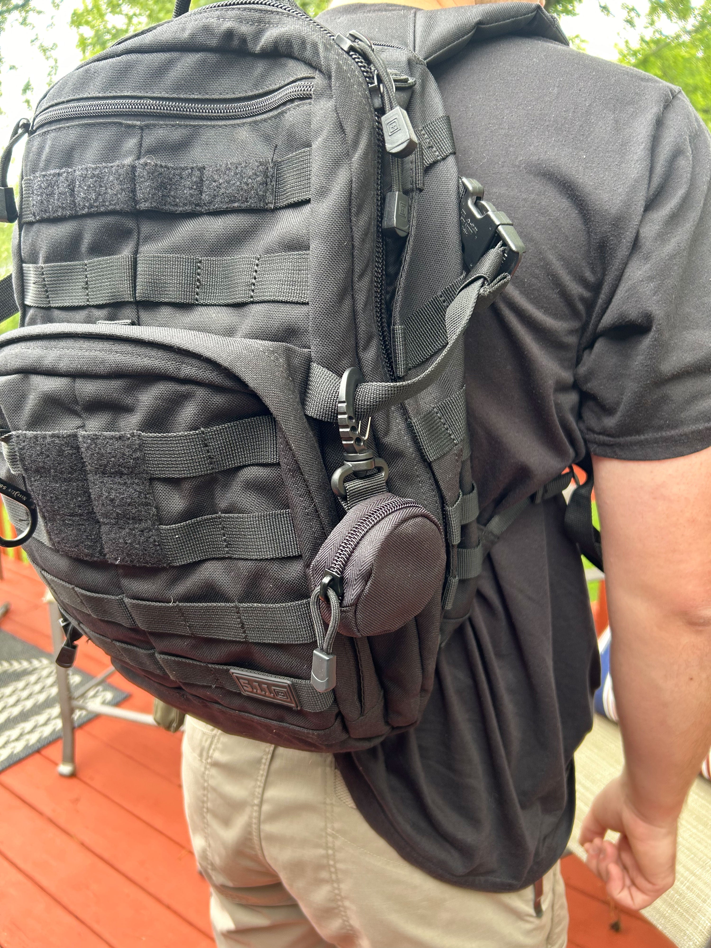 Close-up of a GPS tracking device clipped to tactical gear, showcasing its practical application in outdoor settings